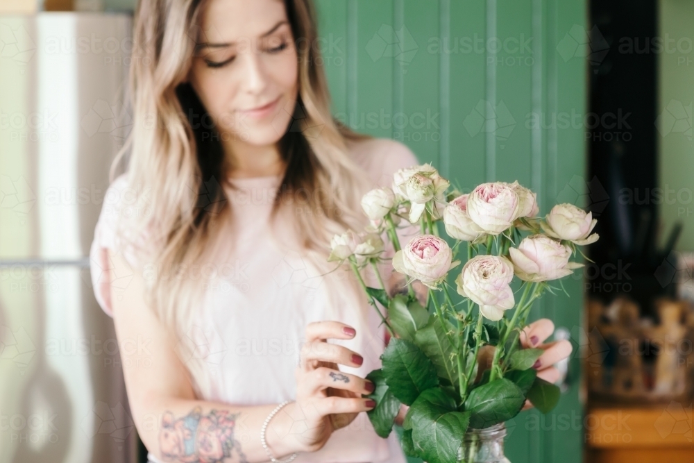 Focus on pretty pink flowers with blurred girl in the background - Australian Stock Image