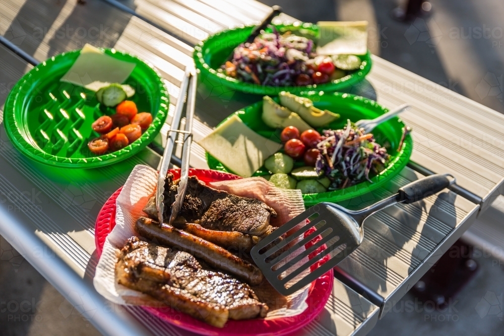 Food on plates on silver table outdoors - Australian Stock Image