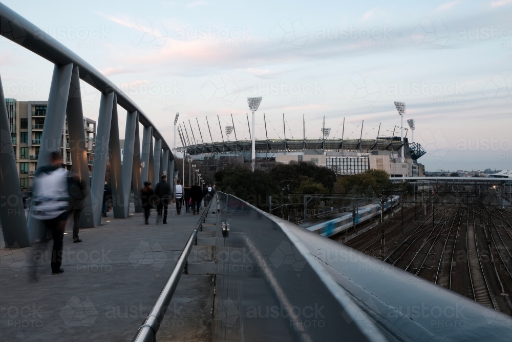 Football Spectators walking on Birrarung Marr towards the MCG - Australian Stock Image