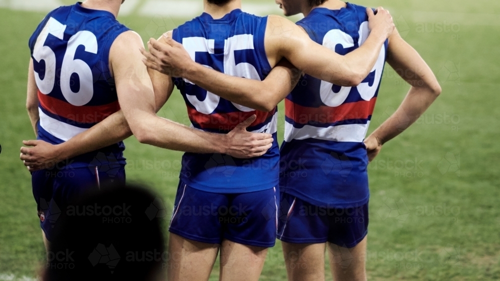 Footballers with Arms Around Each other - Australian Stock Image