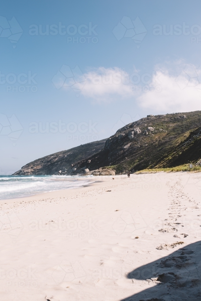 Footprints on secluded beach surrounded by hills - Australian Stock Image