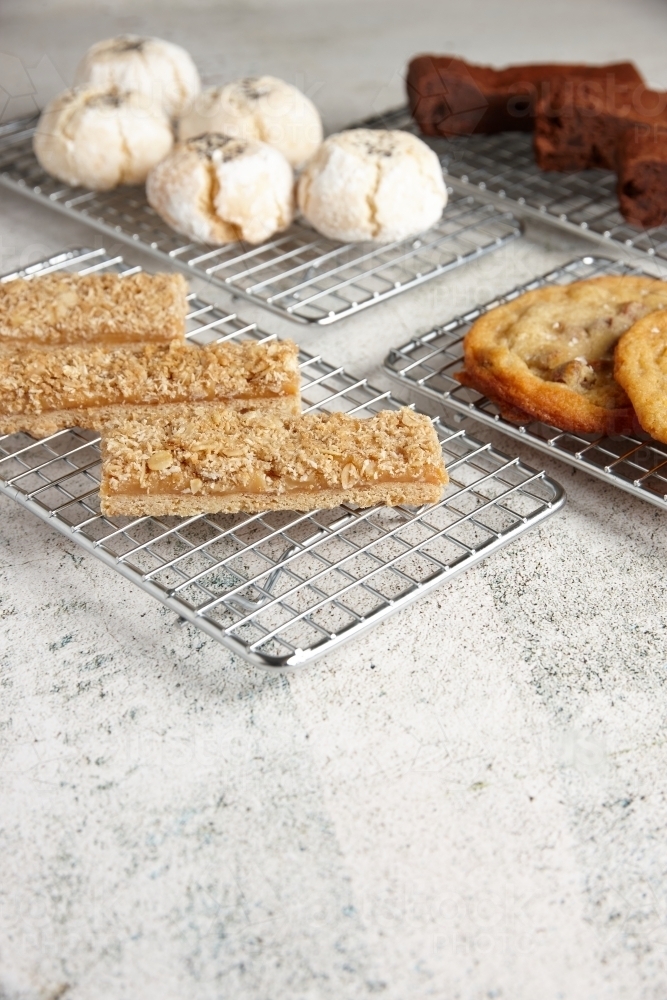 Four baking racks of baked treats at cafe - Australian Stock Image