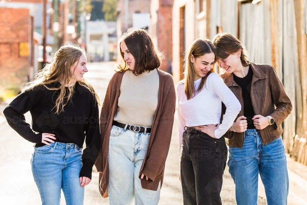 Four girls standing together laughing - Australian Stock Image