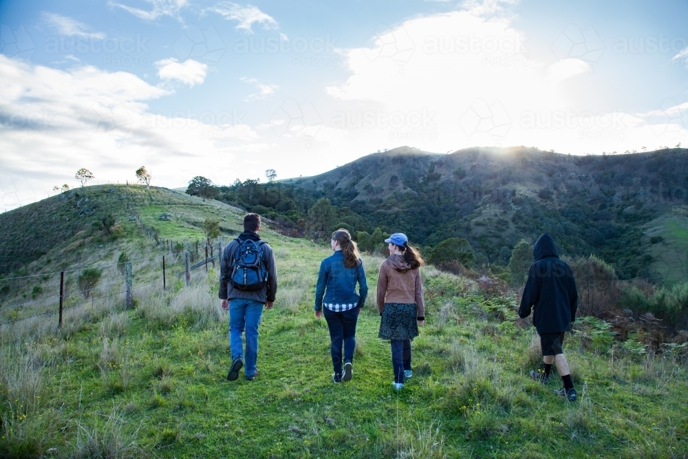 Four teenagers walking up a hill in the early morning - Australian Stock Image