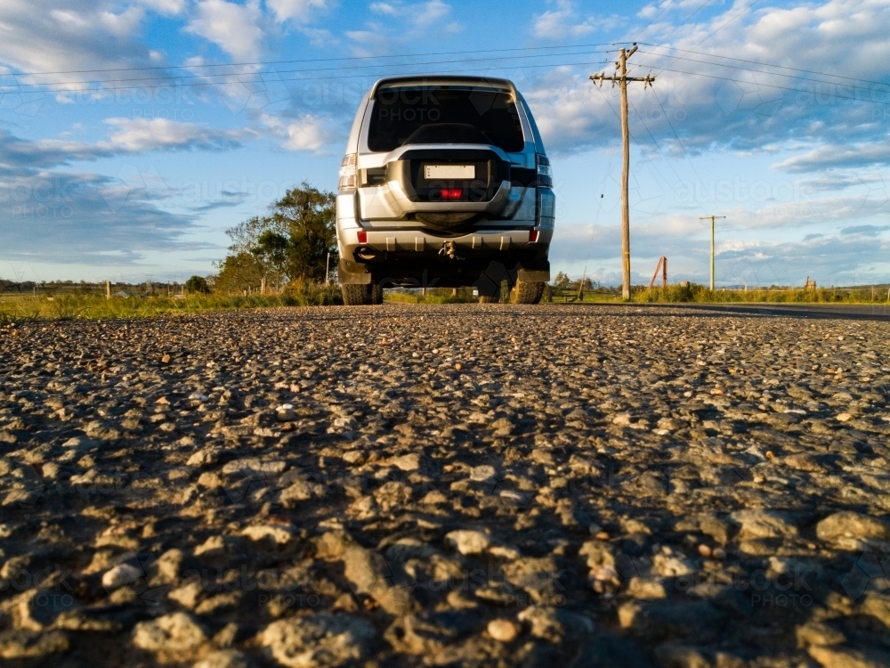 Four wheel drive car low angle view on country road in afternoon - Australian Stock Image