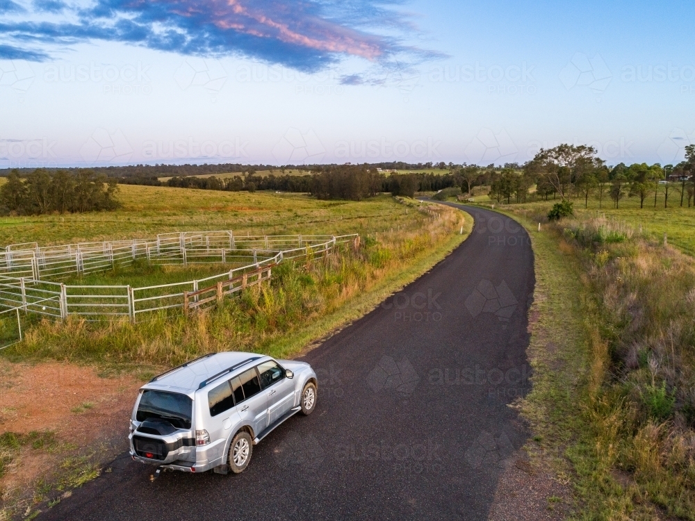 four wheel drive car on narrow country road on road trip adventure at dusk - Australian Stock Image