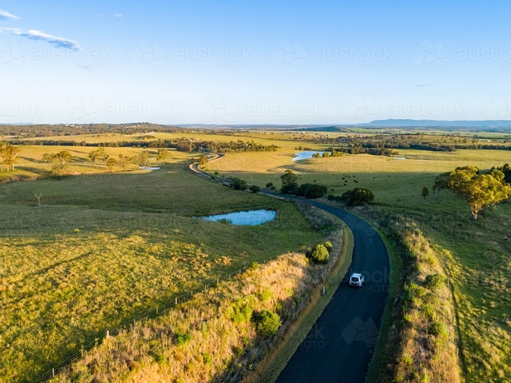 Four wheel drive car on narrow country road trip adventure at sunset - travel insurance concept - Australian Stock Image