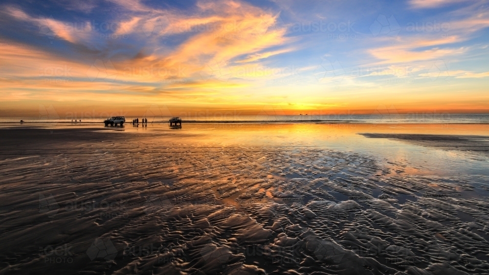 Four wheel drives on beach at sunset - Australian Stock Image