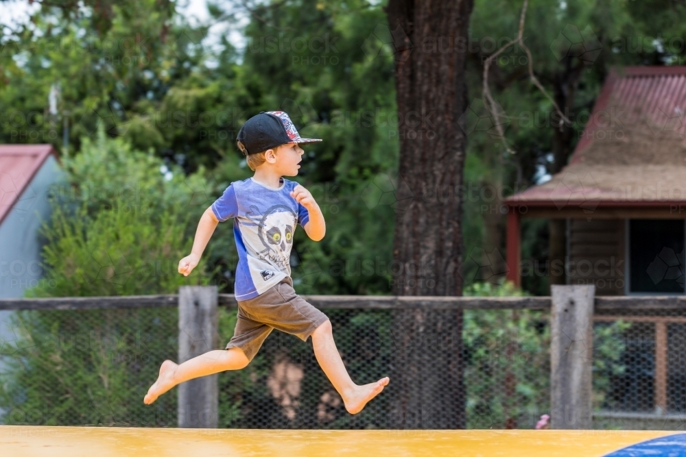 image-of-four-year-old-boy-running-along-jumping-pillow-at-a-holiday