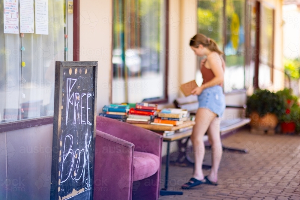 free book stall on footpath with person browsing - Australian Stock Image