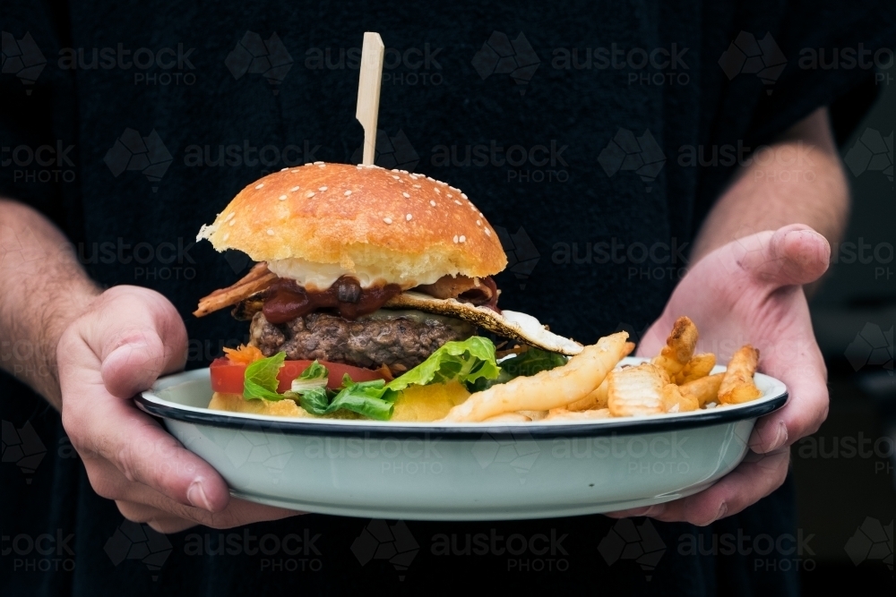 Fresh cooked burger and chips ready to eat - Australian Stock Image
