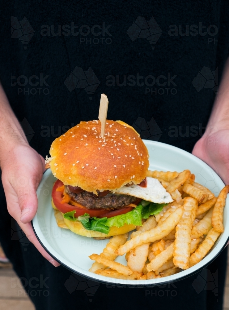 Fresh hamburger and chips on a plate - Australian Stock Image