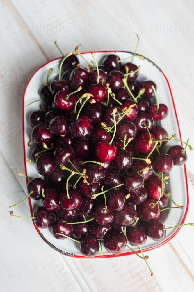 Fresh juicy cherries in an old enamelware dish - Australian Stock Image