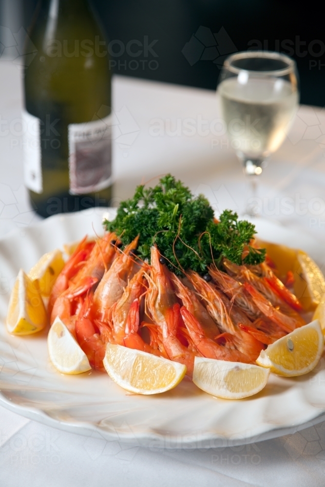 Fresh prawns arranged on a plate with lemon slices - Australian Stock Image