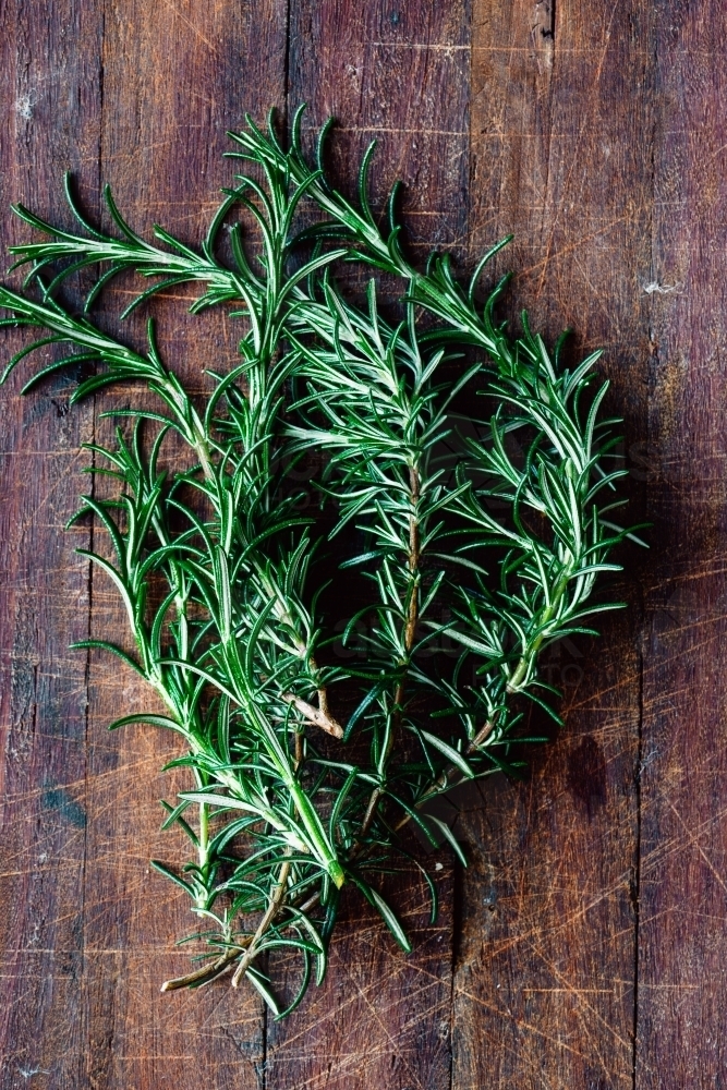 fresh rosemary on a wooden board - Australian Stock Image