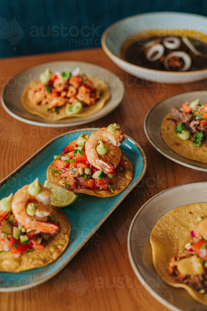 Fresh Shrimp Tacos With Colourful Toppings Served on Wooden Table - Australian Stock Image