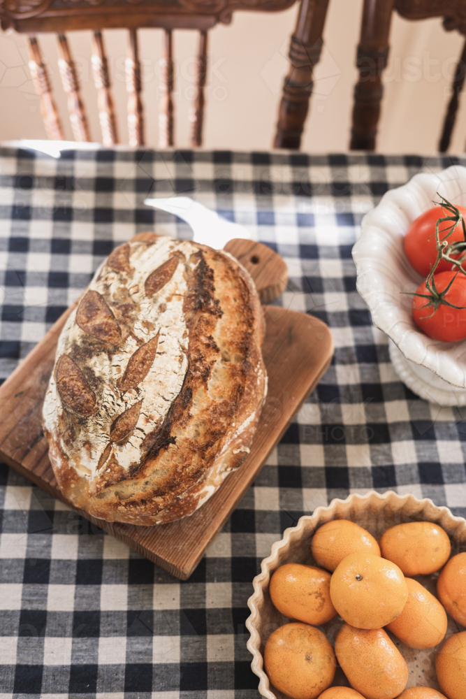 fresh sourdough on gingham tablecloth - Australian Stock Image