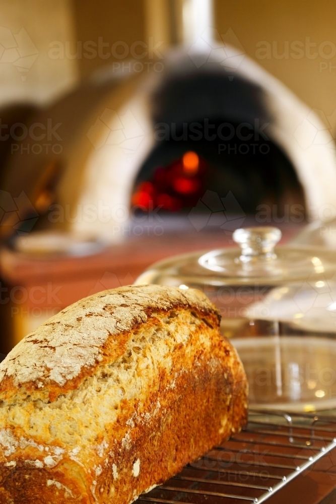 Freshly baked loaf of bread cools after cooking in a wood fired oven. - Australian Stock Image