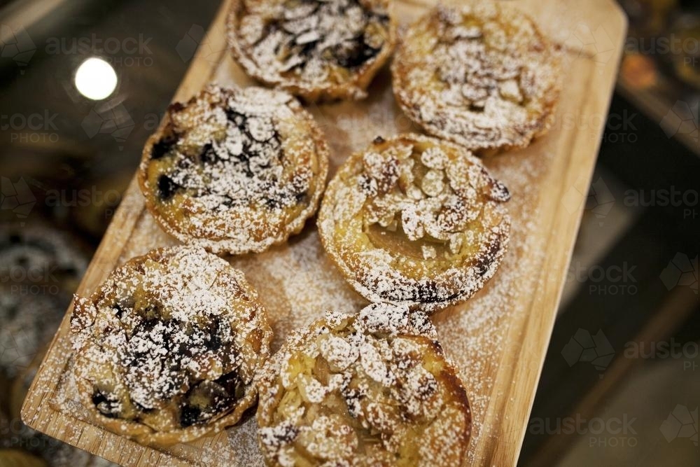 Freshly made tarts on display at bakery cafe - Australian Stock Image