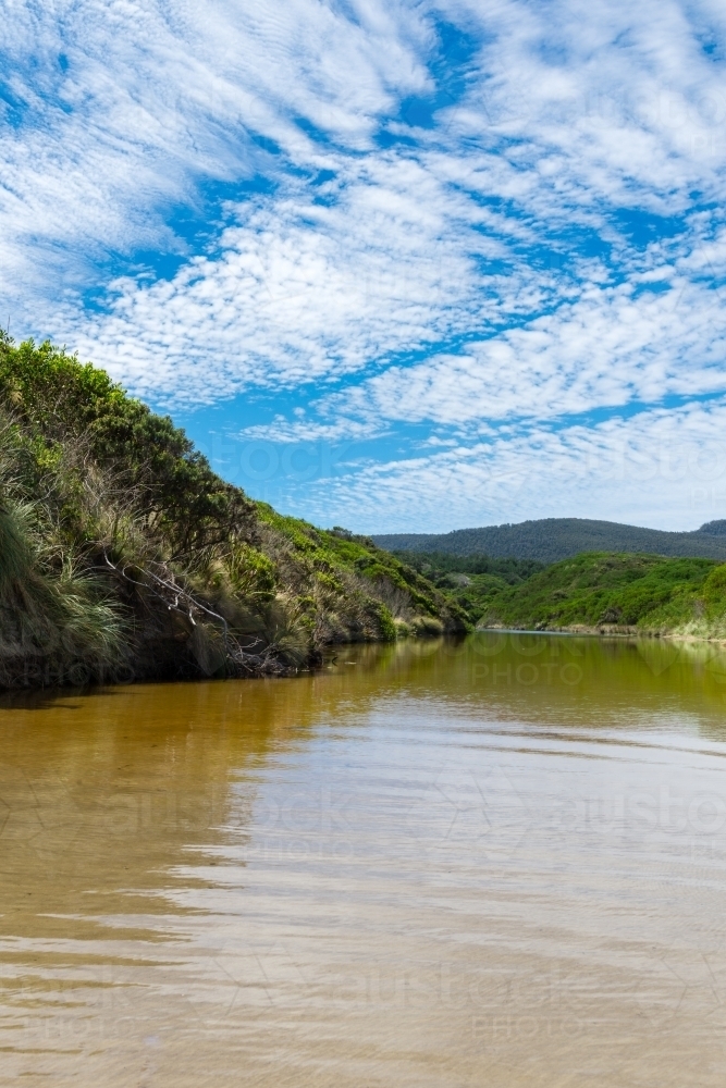 freshwater creek flowing into the ocean - Australian Stock Image