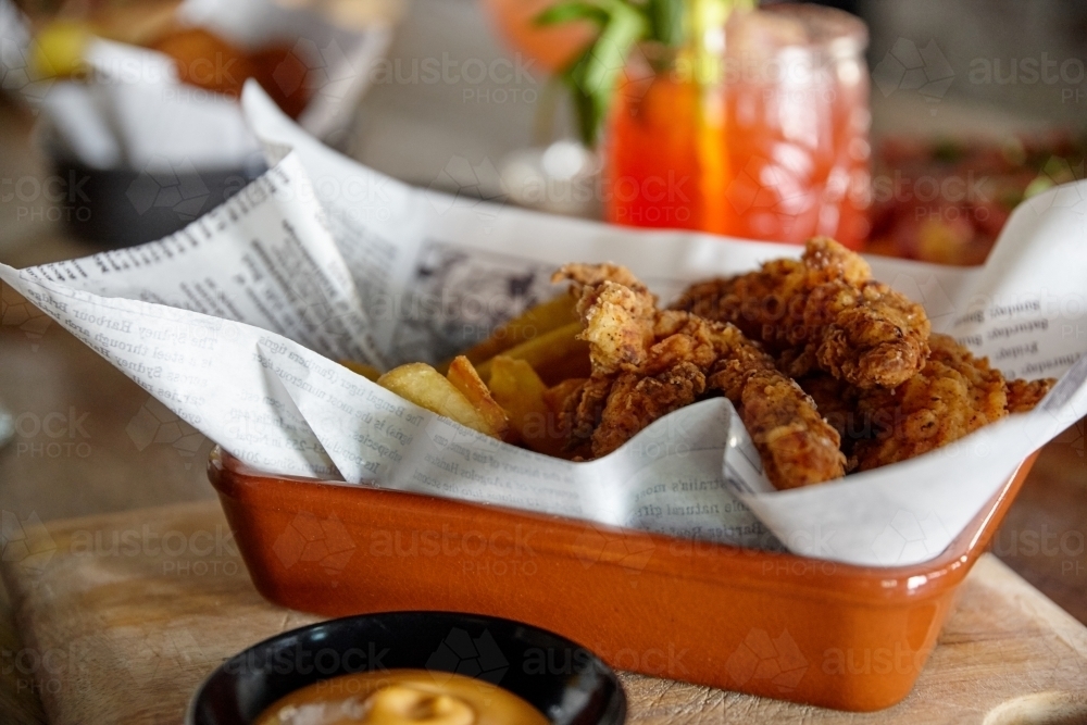 Fried chicken and chips banquet on table - Australian Stock Image