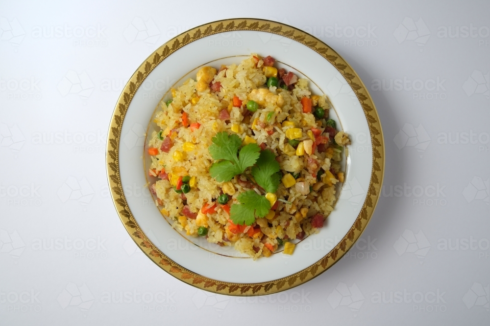 Image of Fried rice with vegetables served in a plate with gold rim ...