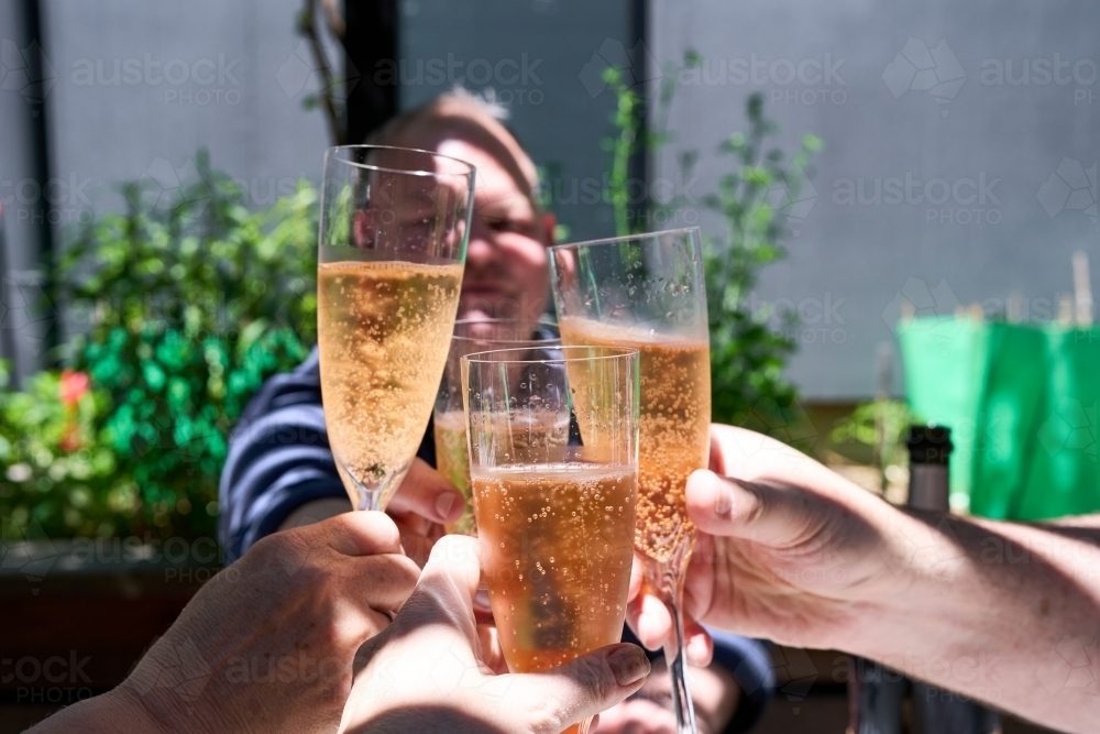 Image of Friends cheering champagne glasses on Christmas Day Austockphoto