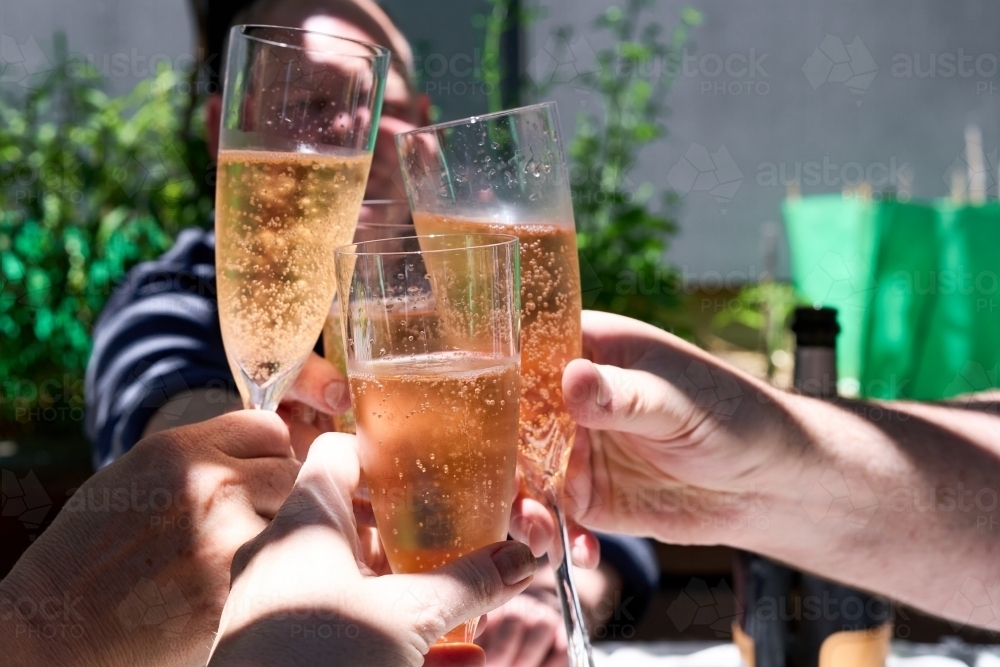 Image of Friends cheering champagne glasses on Christmas Day Austockphoto
