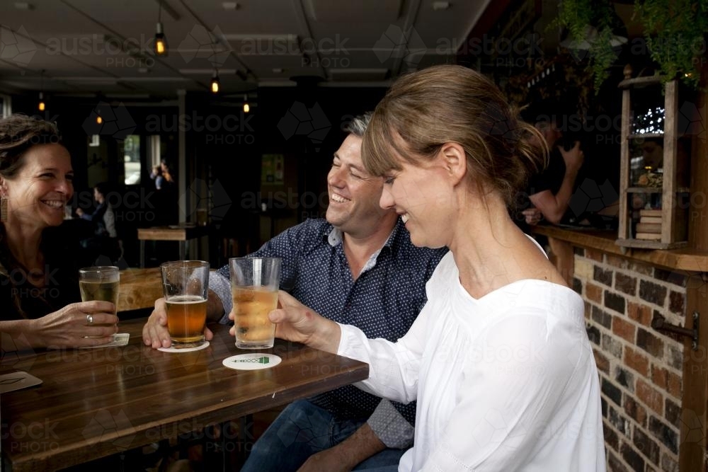 Friends sharing a drink at local craft beer pub - Australian Stock Image