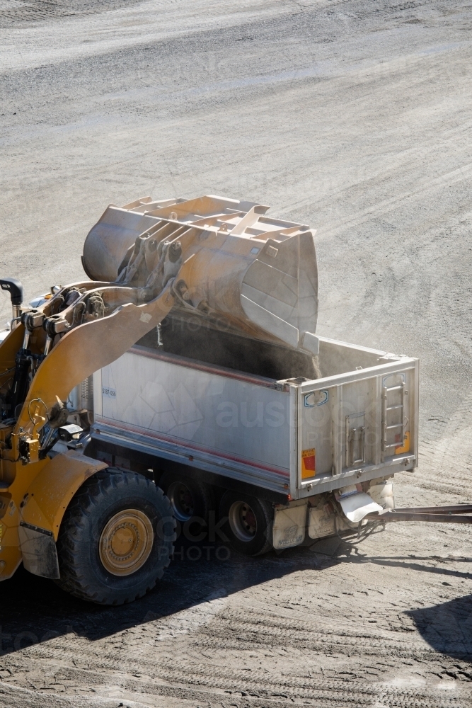 Loading Fronted Image of Front end loader loading a truck in mine - Austockphoto