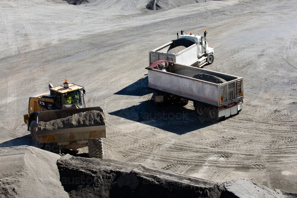 Image of Front end loader loading a truck in mine - Austockphoto