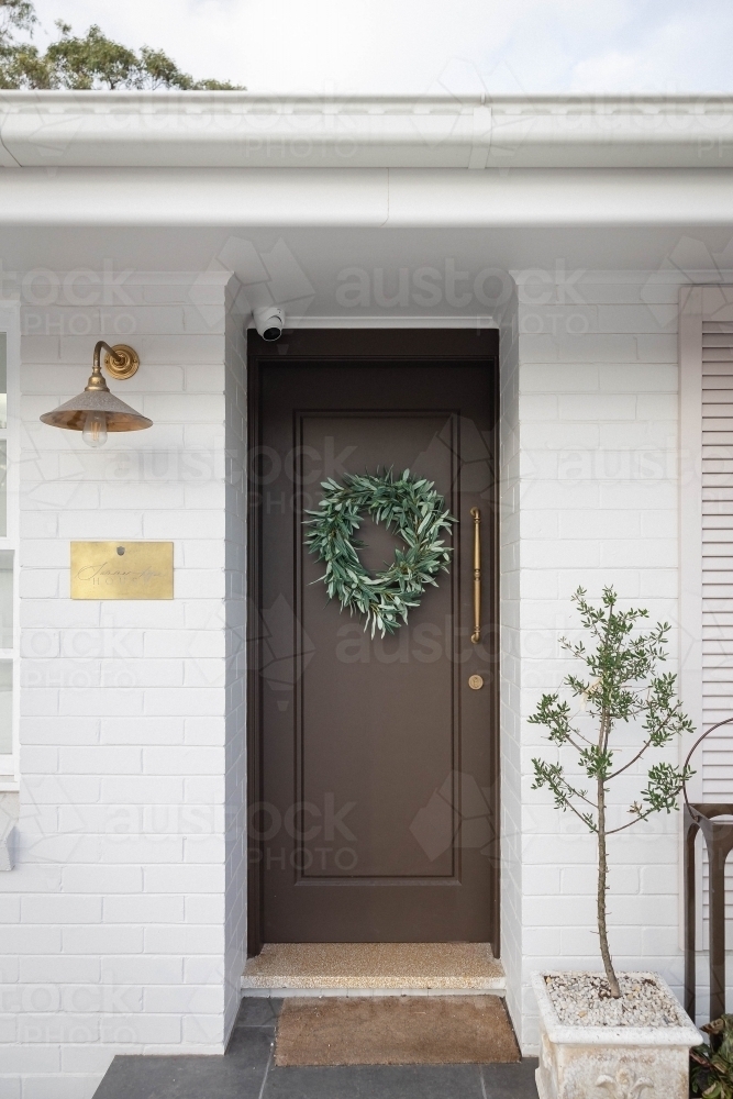 Front porch with wooden door decorated with wreath - Australian Stock Image