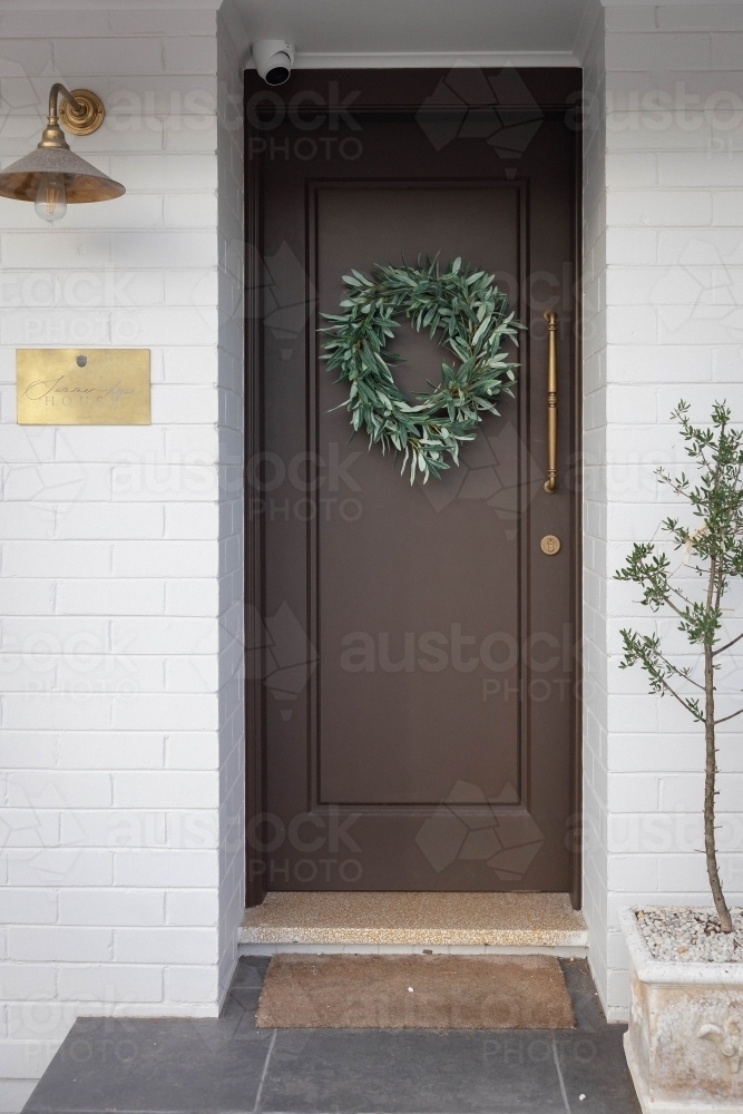Front porch with wooden door decorated with wreath - Australian Stock Image