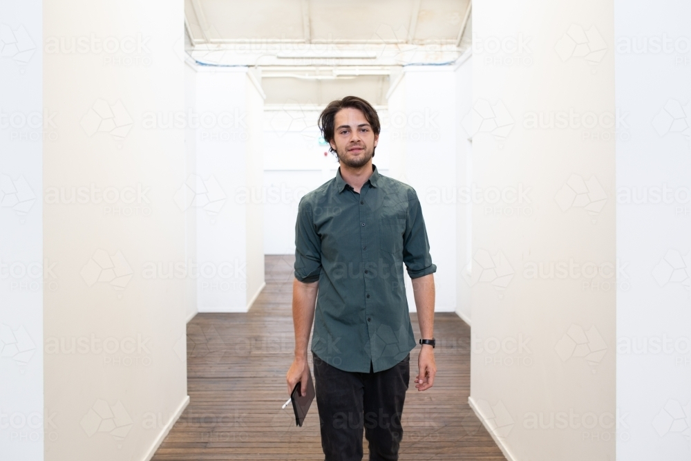 Front view of man walking in the hallway - Australian Stock Image