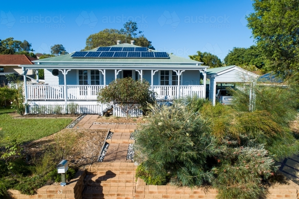 Front view of Queenslander style house with solar panels. - Australian Stock Image
