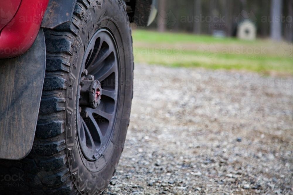 Front wheel of a four wheel drive car on a gravel road - Australian Stock Image
