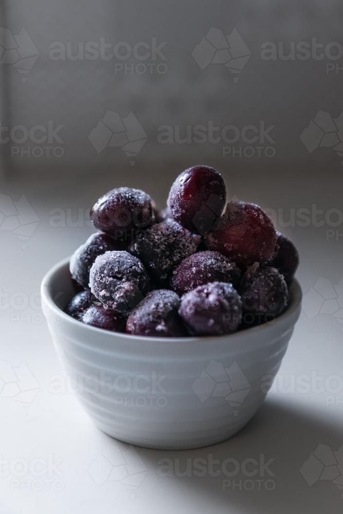 frozen cherries in a white bowl - Australian Stock Image