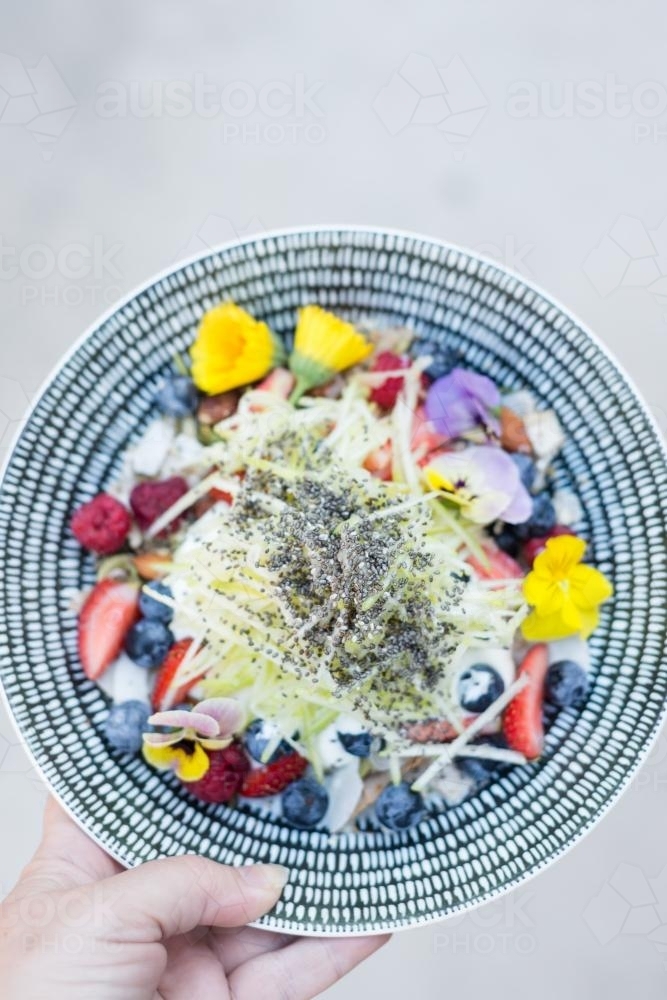 Fruits with yoghurt, chia seeds and edible flowers - Australian Stock Image