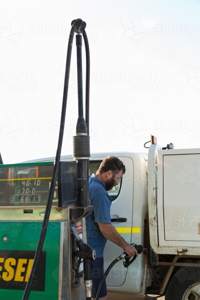 Fuel bowser, with man putting diesel into vehicle - Australian Stock Image