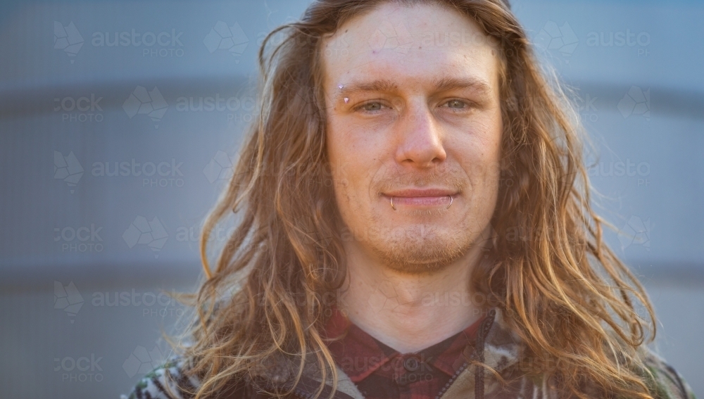 full face of young bloke with long hair and facial piercings - Australian Stock Image