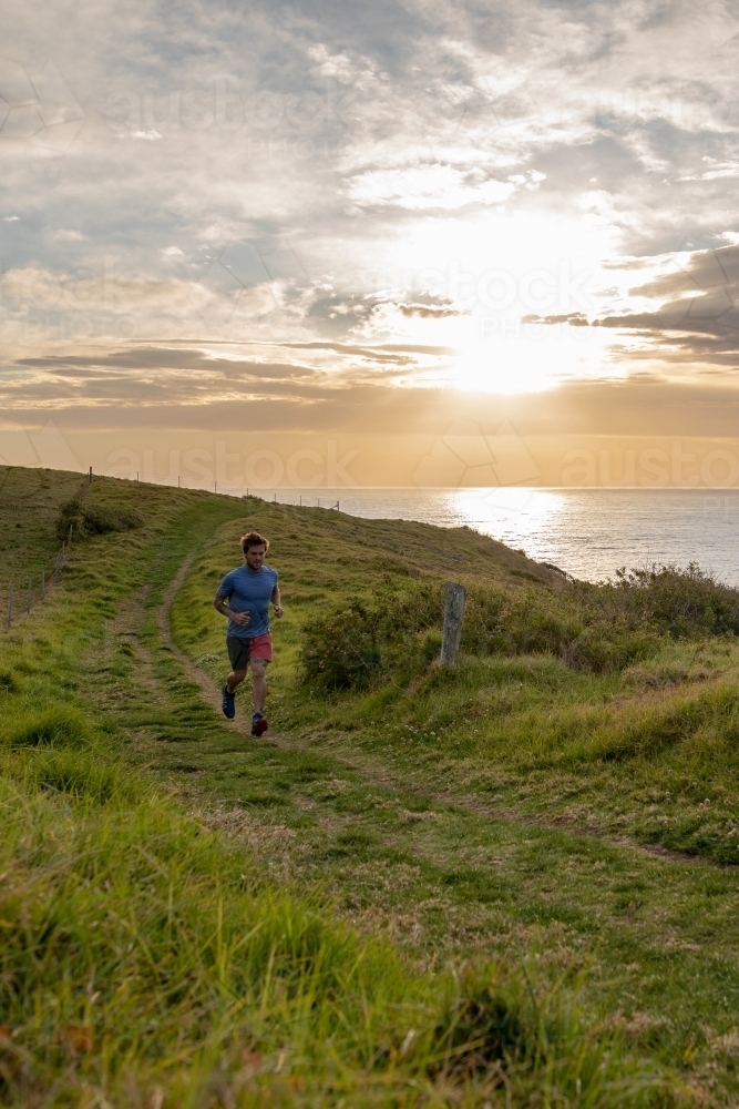 Full Length of Man in Distance Running Along Country Road - Australian Stock Image