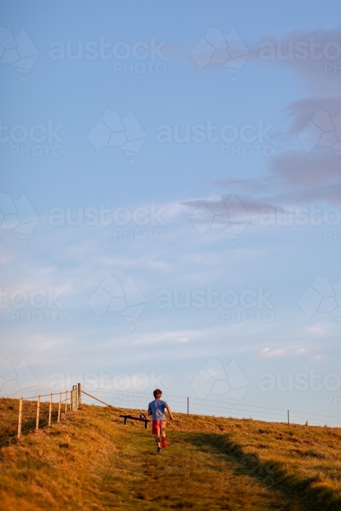 Full Length of Man Running up Hillside - Australian Stock Image