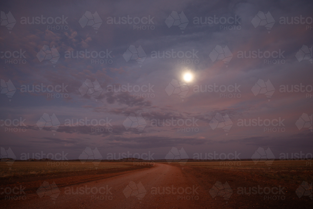 Full moon lighting up a dirt road - Australian Stock Image