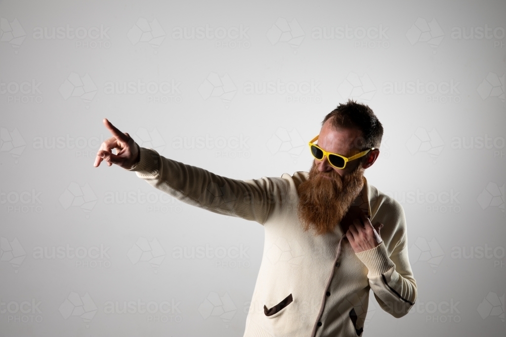 Funky man posing for photographs, wearing a beige shirt - Australian Stock Image