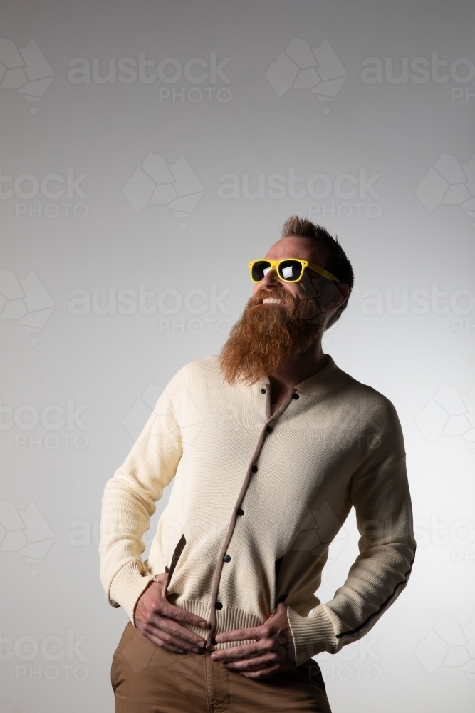 Funky man posing for photographs, wearing a beige shirt - Australian Stock Image