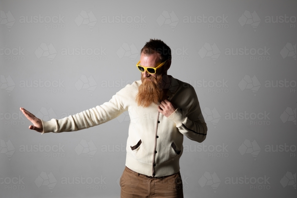 Funky man posing for photographs, wearing a beige shirt - Australian Stock Image