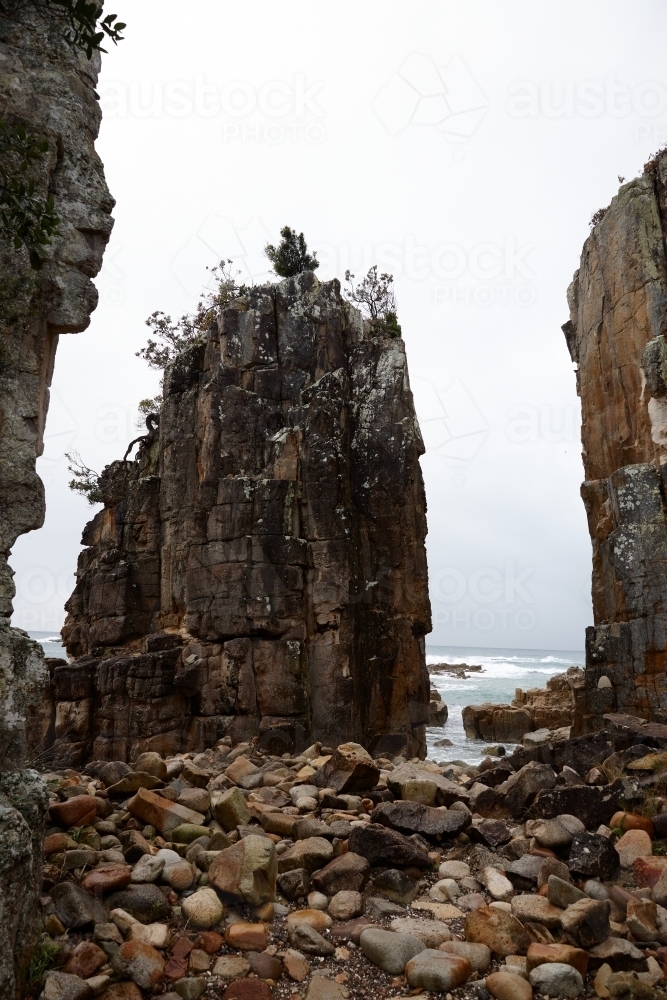 Gap between coastal rocks on overcast morning - Australian Stock Image