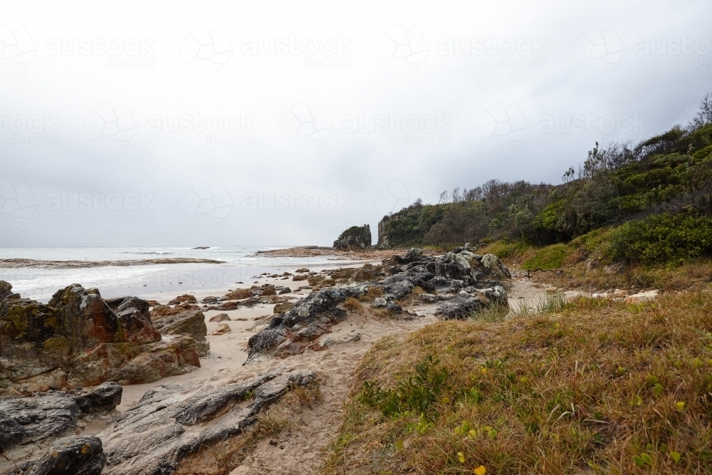 Gap in coastal rocky headland landscape on overcast morning - Australian Stock Image