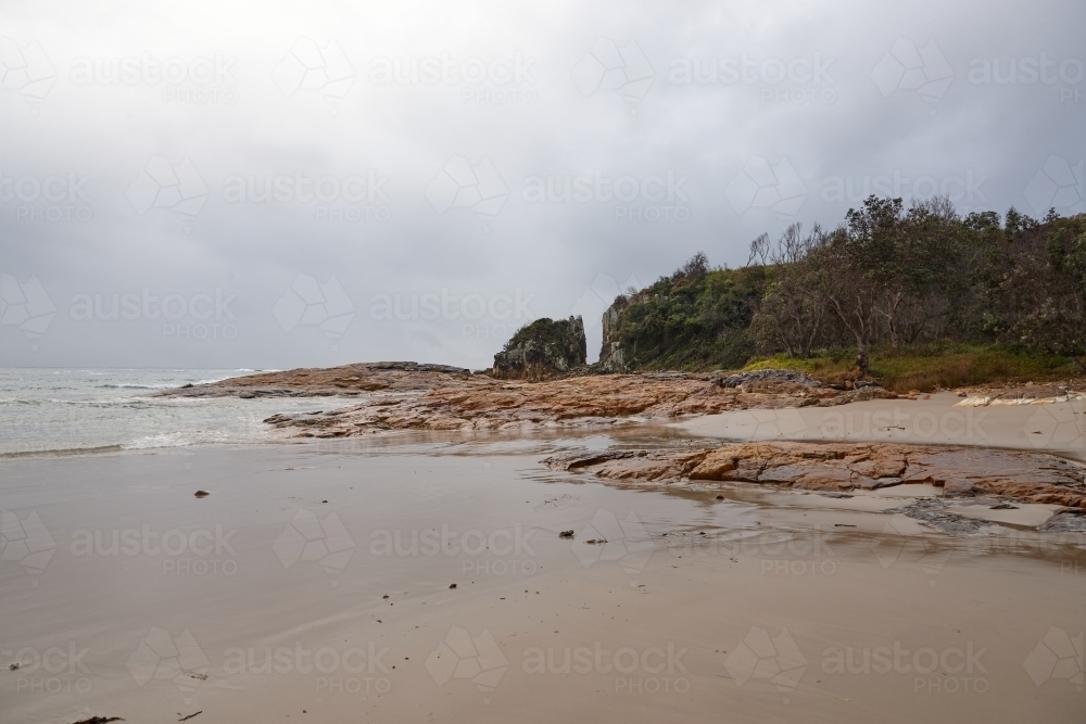 Gap in coastal rocky headland landscape on overcast morning - Australian Stock Image