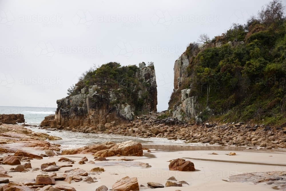 Gap in coastal rocky headland landscape on overcast morning - Australian Stock Image